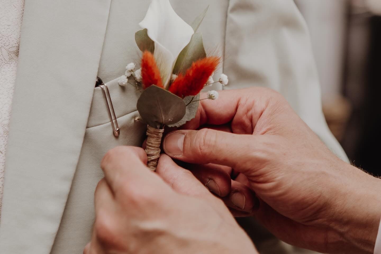 Boutonnière du marié fixée sur le costume
