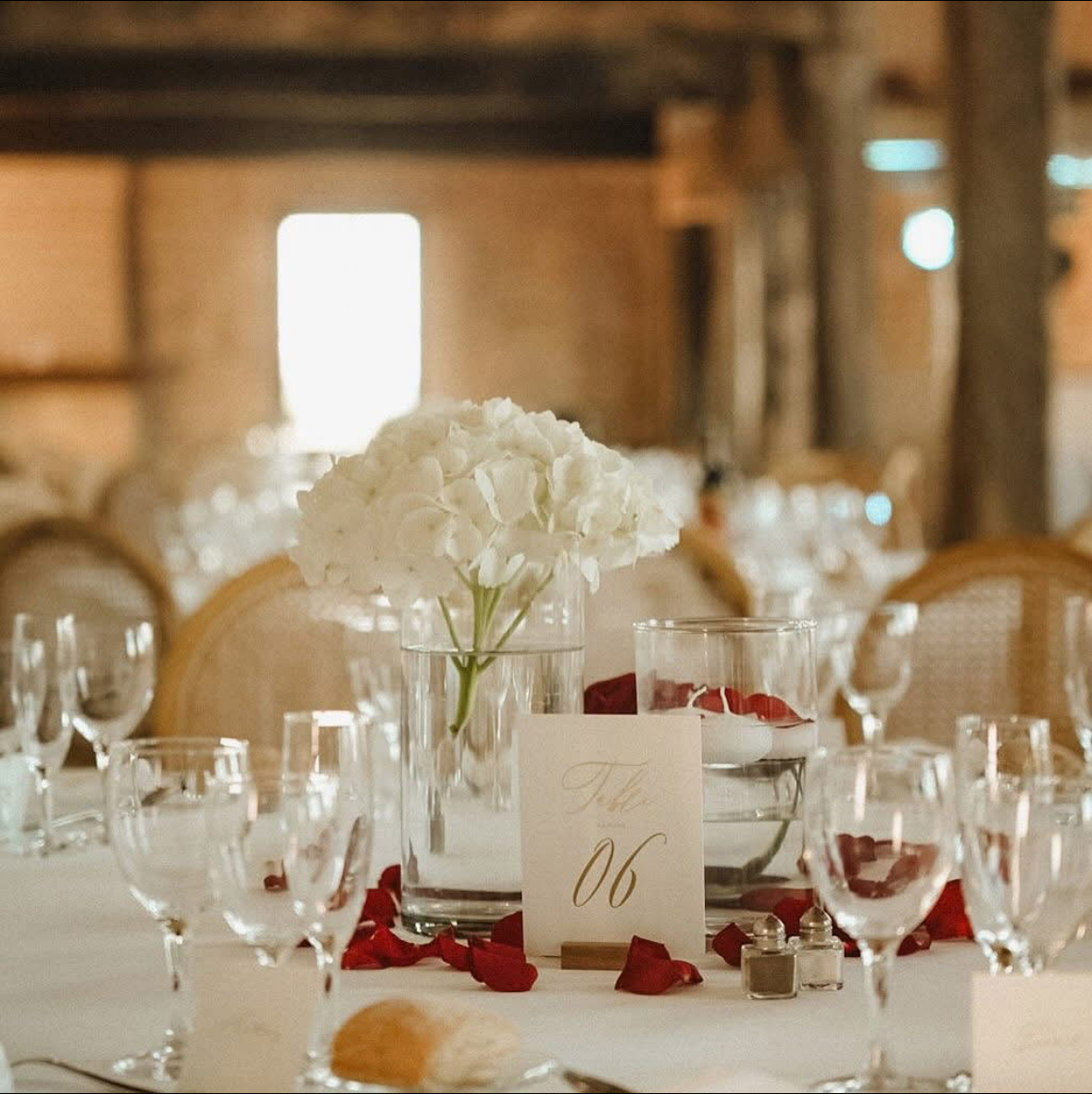 Centre de table mariage avec hortensias blancs et pétales de roses rouges